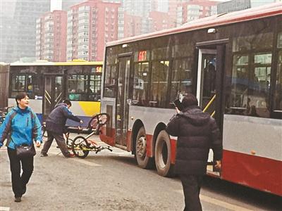 昨天晚高峰时段，两辆共享单车“挂上”公交车 摄影/本报记者 屈畅