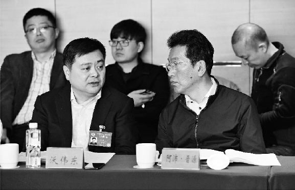 今年两会期间，阿沛·晋源（右）在界别小组讨论会上。    本报记者  齐波  摄