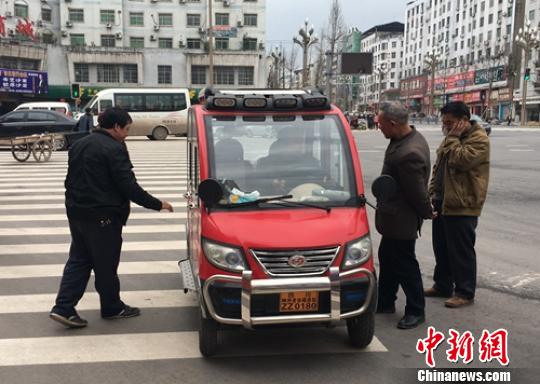 营山城区电动四轮车司机正在讨论车辆的车况。　刘忠俊 摄
