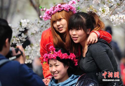 图为清明假日中市民在玉渊潭樱花树下拍下节日图片。<a target='_blank' href='http://www.chinanews.com/'>中新社</a>发 邹宪 摄 