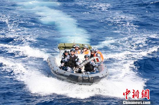 特战队员乘小艇携带挂梯出击，演练解救被劫船舶。　林健 摄