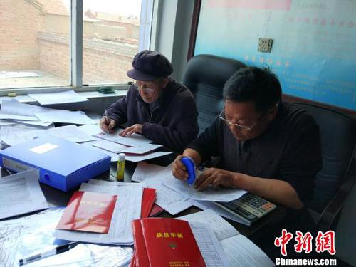 村干部多是60岁以上的老人，他们在忙碌着基层扶贫工作 陈溯 摄