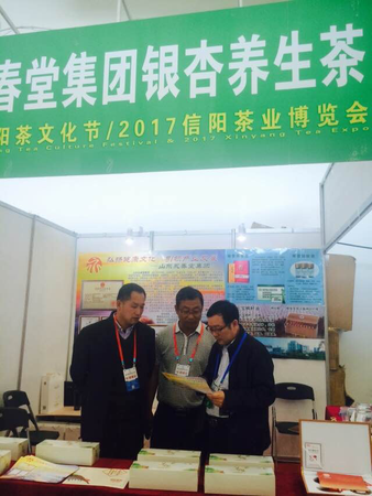 5、来自全国各地的茶商积极参加第25届信阳茶文化节展览展示。图为来自山东省济宁市永春集团的参展商在研究推展措施。  梓涵  摄影