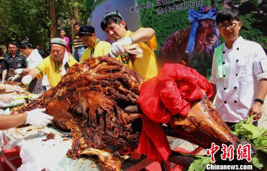 摆上长桌后，厨师们开始切割牛肉。　史玉江　摄