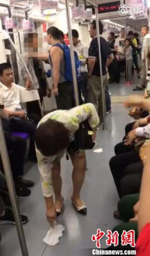 几名男乘客最后将该男子“请”下了车，上海阿姨则用纸巾擦去了地上的痰渍。视频截图