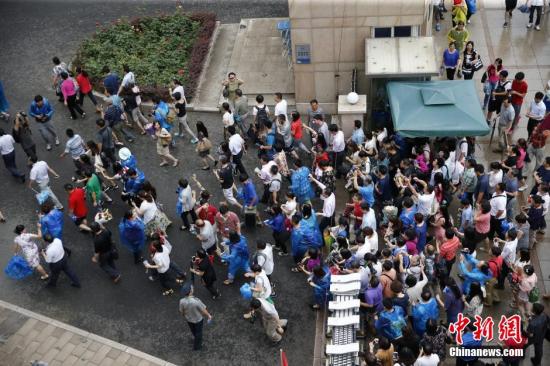 资料图：2015年6月8日下午，北京人大附中考点，众多家长在北京高考最后一门考试结束后冲进学校内迎接考生。<a target='_blank' href='http://www.chinanews.com/'>中新社</a>发 张浩 摄