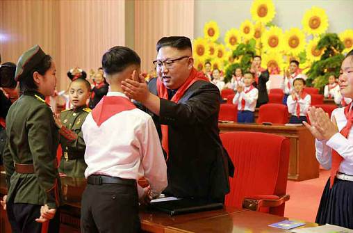 金正恩佩戴红领巾与儿童互动。