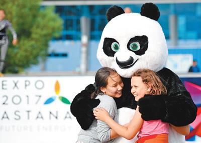 中国侨网图为5日，当地儿童与舞蹈团中代表中国元素的熊猫卡通形象互动。  　　新华社记者  吴晓凌摄
