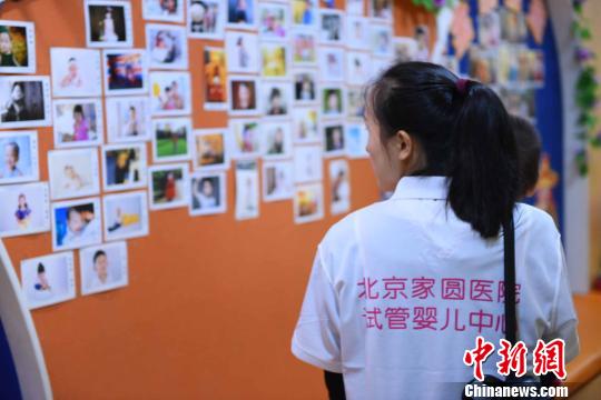 图为当日一名母亲正在观看墙上的“试管宝宝”照片。　徐兆华 摄