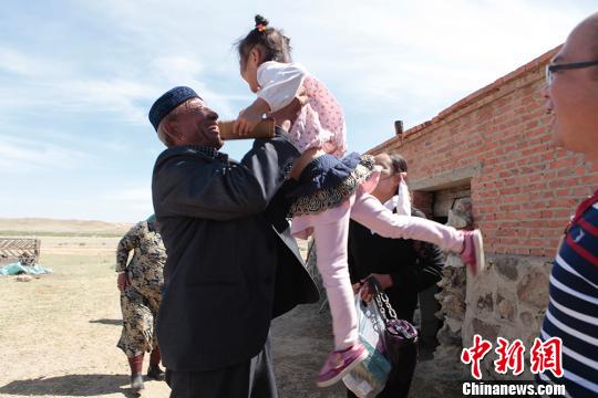 图为张义兵的阿爸将汉族孙女高高举起。　樊晓丽 摄
