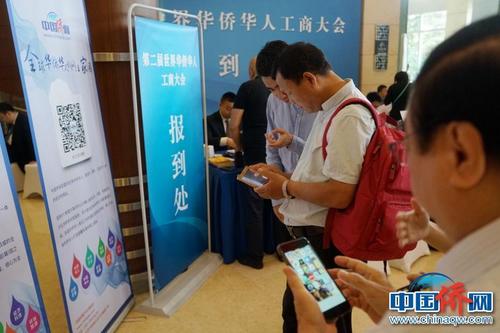 第二届华侨华人工商大会报到现场，中国新闻社“侨宝”客户端及中国侨网微信宣传品吸引了高度关注，嘉宾纷纷扫码下载。付强 摄