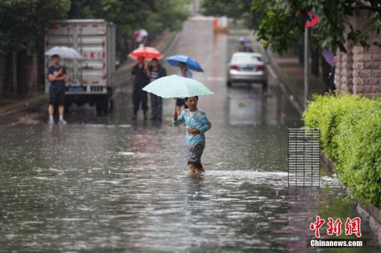 6月12日，市民在积水的道路中出行。当日，贵阳市气象台于6时28分将暴雨黄色预警信号升级为暴雨红色预警信号，持续降雨造成贵阳市多处路段严重积水。<a target='_blank' href='http://www.chinanews.com/'>中新社</a>记者 贺俊怡 摄