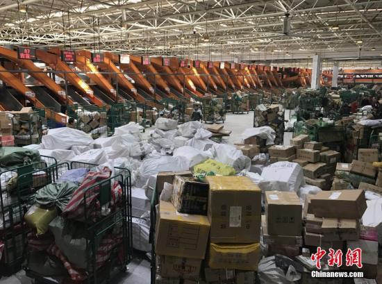 1月20日，湖南长沙邮区中心局的工作人员正在处理堆积的快递包裹。随着中国春节的临近，为了避开实体店购物的拥挤和繁琐，越来越多的人选择网络购置年货，快递行业也随之迎来“春运”高峰。<a target='_blank' href='http://www.chinanews.com/'>中新社</a>记者 唐小晴 摄