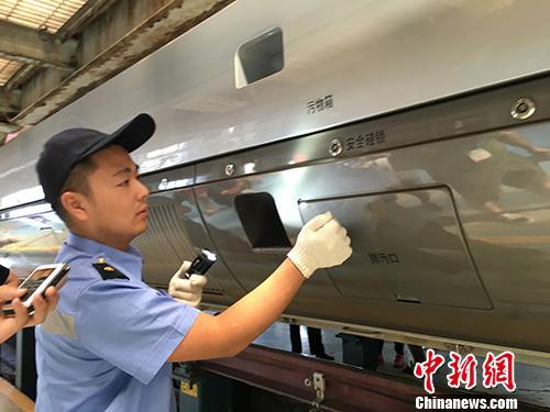 26日上午，北京铁路局北京动车段地勤机械师贾虹升正在为“复兴号”进行检查。中新网记者 翟璐 摄