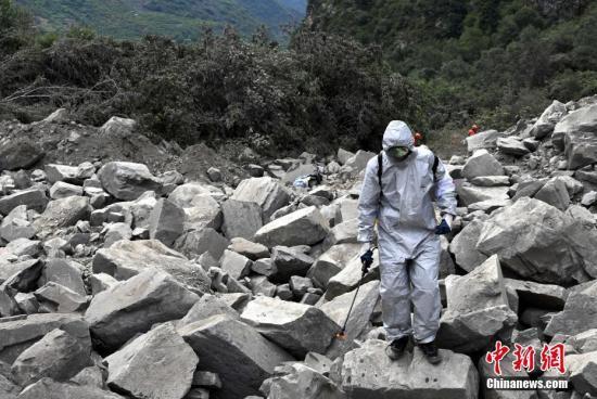 6月26日，四川茂县叠溪镇新磨村新村组富贵山“6·24”特别重大山体滑坡灾害搜救工作进入第3天，上千名救援人员坚守现场全力搜救。图为防疫人员进行消毒防疫。 中新社记者 安源 摄