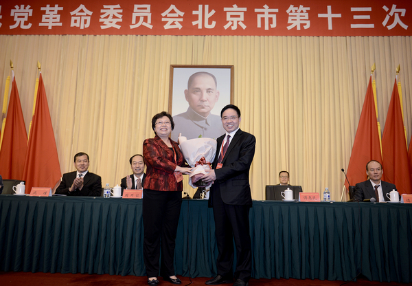 民革北京市第十五届委员会主任委员王红向民革北京市第十四届委员会主任委员傅惠民鲜花。17