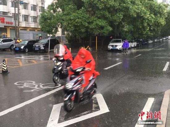 图为北京市民雨中骑行。 <a target='_blank' href='http://www.chinanews.com/' >中新网</a>记者 富宇 摄