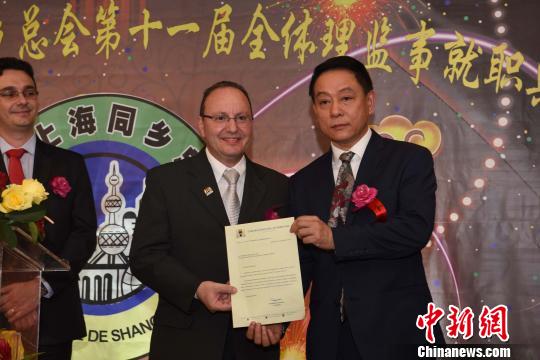 图为巴西圣保罗市政厅代表给巴西上海同乡总会会长郑小云(右一)递交贺信。　莫成雄 摄