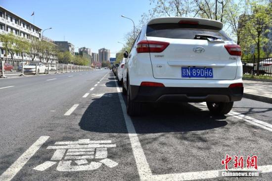 近日，北京市石景山苹果园南路出现了一种新式路侧停车位，位置从紧贴便道旁边挪到了机动车道和非机动车道中间。据交管部门介绍，这样的停车位在全市还属首创，目的是为了解决停车难的同时保障非机动车的路权。新式路侧停车位设置在路南侧近30余个，位于两条机动车道和一条非机动车道中间，停车位内已经都停满了私家车，骑车人使用最外侧的自行车专用道，与行驶的机动车隔离开来，互不影响。停车位左侧还划有一米左右宽的虚线边框，提醒司机“注意安全”。<a target='_blank' href='http://www.chinanews.com/' >中新网</a>记者 金硕 摄