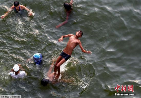 今年夏天，世界各地迎来持续高温天气。世界气象组织(WMO)指出，在观测历史上最热的2016年的气候现象后，专家预计今年也将持续或多发热浪及大雨等极端天气，主要是由于温室气体浓度和海水表面温度的上升加剧了全球变暖。世界各地纷纷进入“烧烤模式”。图为当地时间6月16日，印度阿拉哈巴德，一名男孩在亚穆纳河嬉水。