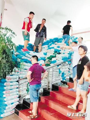 在宁乡救灾一线，一位“独臂大叔”用左手搬运大米，感动了不少人。 长沙晚报通讯员 杨欣 摄 