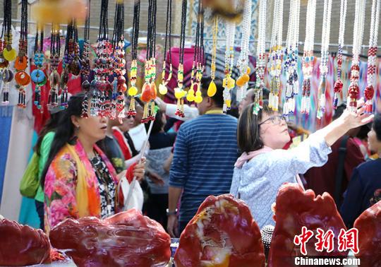图为华教代表在观看民族特色工艺品。　耿丹丹 摄