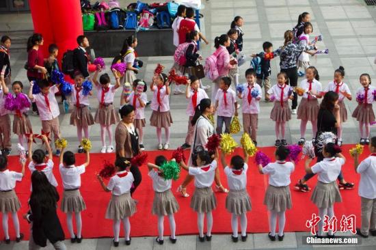 9月10日是一年一度的教师节。9月9日，山西太原新建路小学的教师们在学生们的欢呼簇拥下像明星一样走红毯展风采、秀签名，并接受他们崇高的敬礼与祝福。图为孩子们夹道欢迎老师走红毯展风采。张云 摄