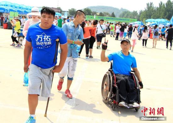 6月18日，由石家庄市体育局“全城热练”全民健身品牌重点打造的精品赛事“2016石家庄(正定)国际徒步大会”，在河北正定滹沱河风景区举行。随着“徒步走”成为世界性的时尚健康运动，越来越多的民众参与其中。本届徒步大会吸引了万余名爱好者参与，线路贯穿石家庄市滹沱河绿色生态长廊，主会场和起点在冀之光广场，共设立了三条徒步线路：休闲组(10公里)、健身组(20公里)、明星组(30公里)，是继石家庄(正定)马拉松之后推出的又一张城市名片。图为“王者归来”独腿徒步者完成10公里路段。 韩冰 摄