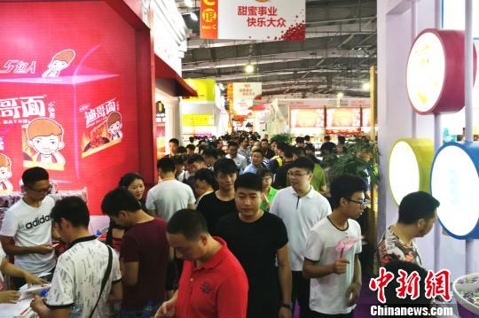 今年“两岸食交会”吸引了400多家特色食品企业参展，展馆内人潮涌动。　孙虹 摄