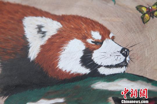 图为珞碧迈创作的4副“嘟嘟”圆木板画像。　钟欣 摄