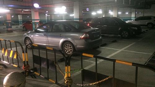 图说：售楼处的地下车库，保安人员架设铁马隔离栏，小区业主不可在此区域停车。戴天骄 摄