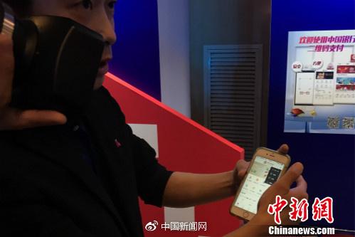 一位工作人员正在教体验者使用银联云闪付产品。中新网种卿摄