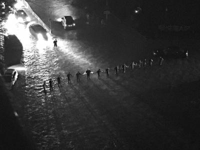 暴雨中，抢险队员站成“人墙”，引导交通。刘瑜摄 