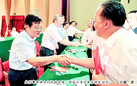光彩事业凉山行活动现场，徐乐江为企业家颁发证书。  张雷  摄