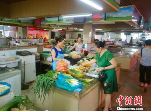 资料图：民众正在菜场挑选蔬菜水果。　赵侃一 摄