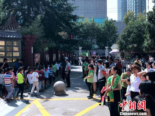 图为学校门口挤满了学生家长。　梅镱泷 摄
