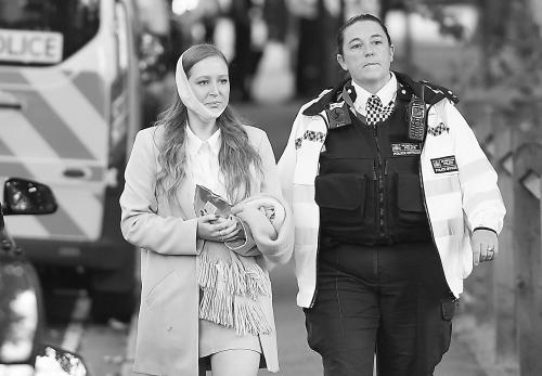 英国安全人员陪同伤者离开爆炸现场。