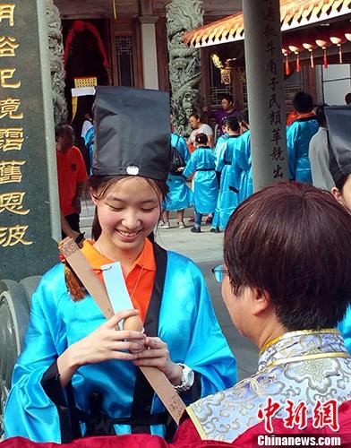 9月22日至24日，由马祖县政府与厦门陆岛旅游投资有限公司联合举办的两岸成年礼活动在马祖举行。来自福州、厦门、龙岩和马祖的260多位两岸学子参加活动。图为9月23日下午，马祖牛角五灵公庙前，“做出幼”作为本届两岸成年礼系列活动之一隆重举行。仪式上，身着汉服的马祖高中生，由长辈加冠，吃平安蛋，饮成年酒。 <a target='_blank' href='http://www.chinanews.com/'>中新社</a>记者 邢利宇 摄