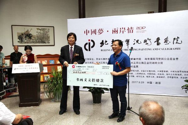 9月29日，在中国梦·两岸情画展开幕式上，民革株洲市委主委刘春正在接受北京正举沈鹏书画院院长沈鹏的义卖捐赠。