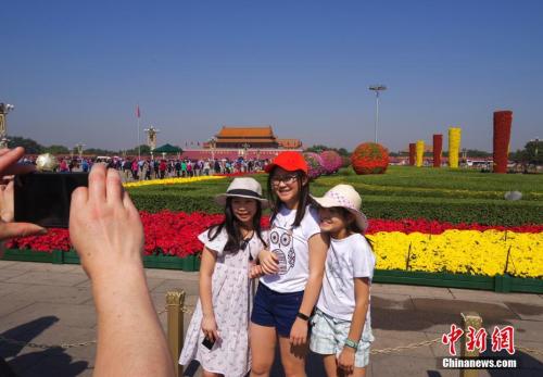 9月29日，三位小游客在北京天安门广场国庆花坛前留影。 <a target='_blank' href='http://www.chinanews.com/'>中新社</a>记者 贾天勇 摄