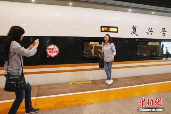 资料图：旅客与“复兴号”列车合影留念。殷立勤 摄
