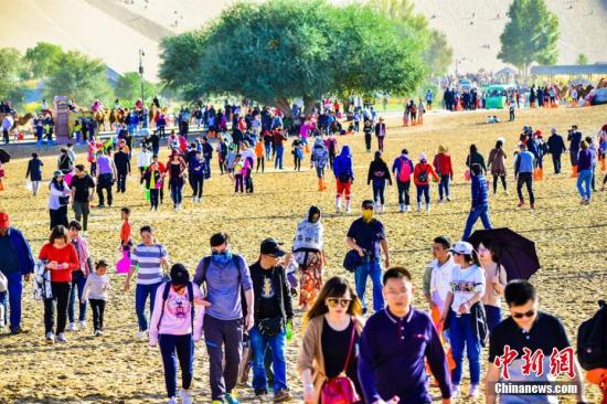 今年“十一”黄金周期间，丝绸之路国际旅游名城甘肃敦煌天气晴好，景色如画。敦煌深厚的历史文化和雄浑的大漠风光，吸引了大批海内外游客纷至沓来，敦煌旅游再度火爆。10月3日，鸣沙山月牙泉景区接待游客29524人次，创景区单日接待游客人数最高纪录。据敦煌市旅游局统计：截至10月3日，敦煌市共接待中外游客11.07万人次，同比增长17.14%，实现旅游收入1.12亿元，同比增长17.94%。其中，莫高窟接待游客51485人次，同比增长8.45%；鸣沙山月牙泉景区接待游客65386人次，同比增长13.75%；雅丹景区接待游客10787人次，同比增长18.93%；阳关景区接待8924人次，同比增长48....
