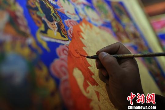 图为阿阿扎巴绘制唐卡。　王鹏 摄