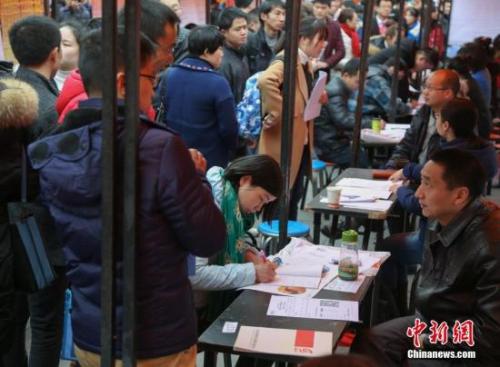 资料图：在武汉市纳杰人才市场招聘会上，挤满了前来应聘的求职者。<a target='_blank' href='http://www.chinanews.com/'>中新社</a>记者 张畅 摄