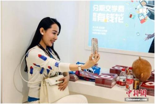 随着移动互联网的发展，各类游戏、旅游、购物等户外户内的移动直播近五年蓬勃发展。图为一名女主播用手机在一家直播平台上做现场直播。<a target='_blank' href='http://www.chinanews.com/'>中新社</a>记者 张浩 摄
