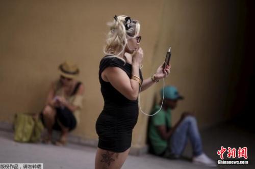资料图片：人们拿着手机站在或坐在一个WiFi热点的附近。