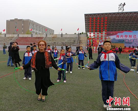 西班牙马德里爱华中文学校校长黄小捷饶有兴致地与学生进行跳绳比赛。　杨杰英 摄