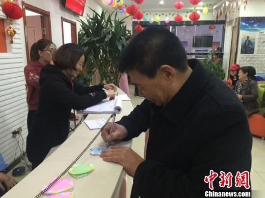 图为老人在便利贴上写下自己的心愿。　杨娜 摄