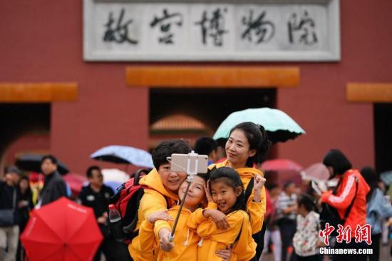10月2日，北京小雨，游客在故宫博物院游览。根据国家旅游局数据中心综合测算，中国国庆假期首日，全国当天共接待游客1.13亿人次，同比增长10.5%，实现旅游收入965亿元，同比增长12.2%。<a target='_blank' href='http://www.chinanews.com/'>中新社</a>记者 杜洋 摄