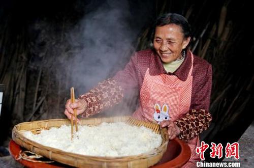韩进先把蒸熟的糯米在筲箕中进行摊凉。　杨涛 摄